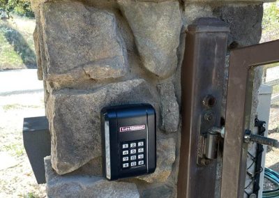 Dual swing gate, ranch style, Liftmaster actuator arms system replacement. We’ve removed an old Liftmaster miracle automatic gate actuator and put in new LA500 actuators with a new control box and a new KPW-5 keypad to work with it.